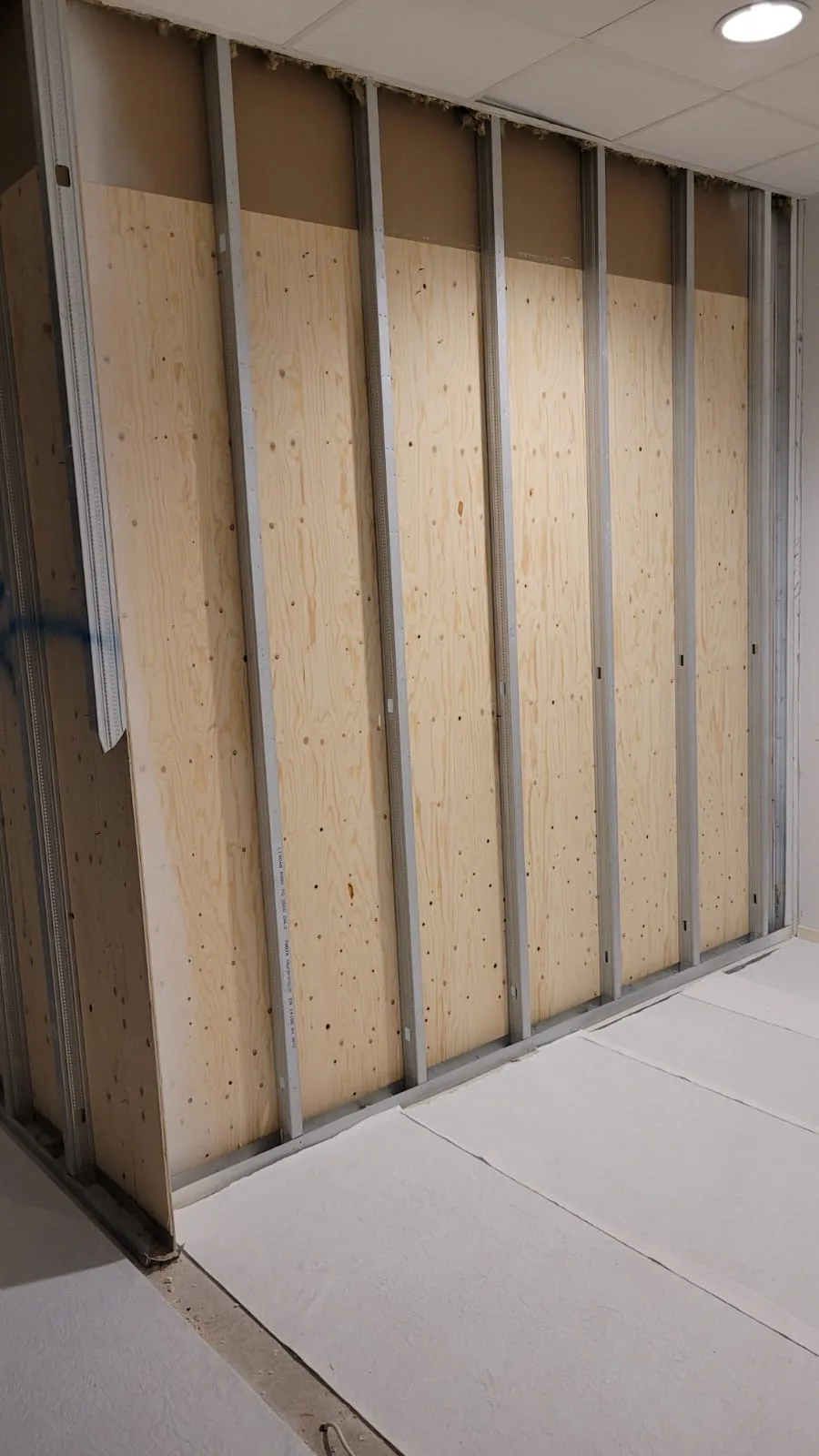 Inre i pågående byggarbete med stålram och plywoodskivor
