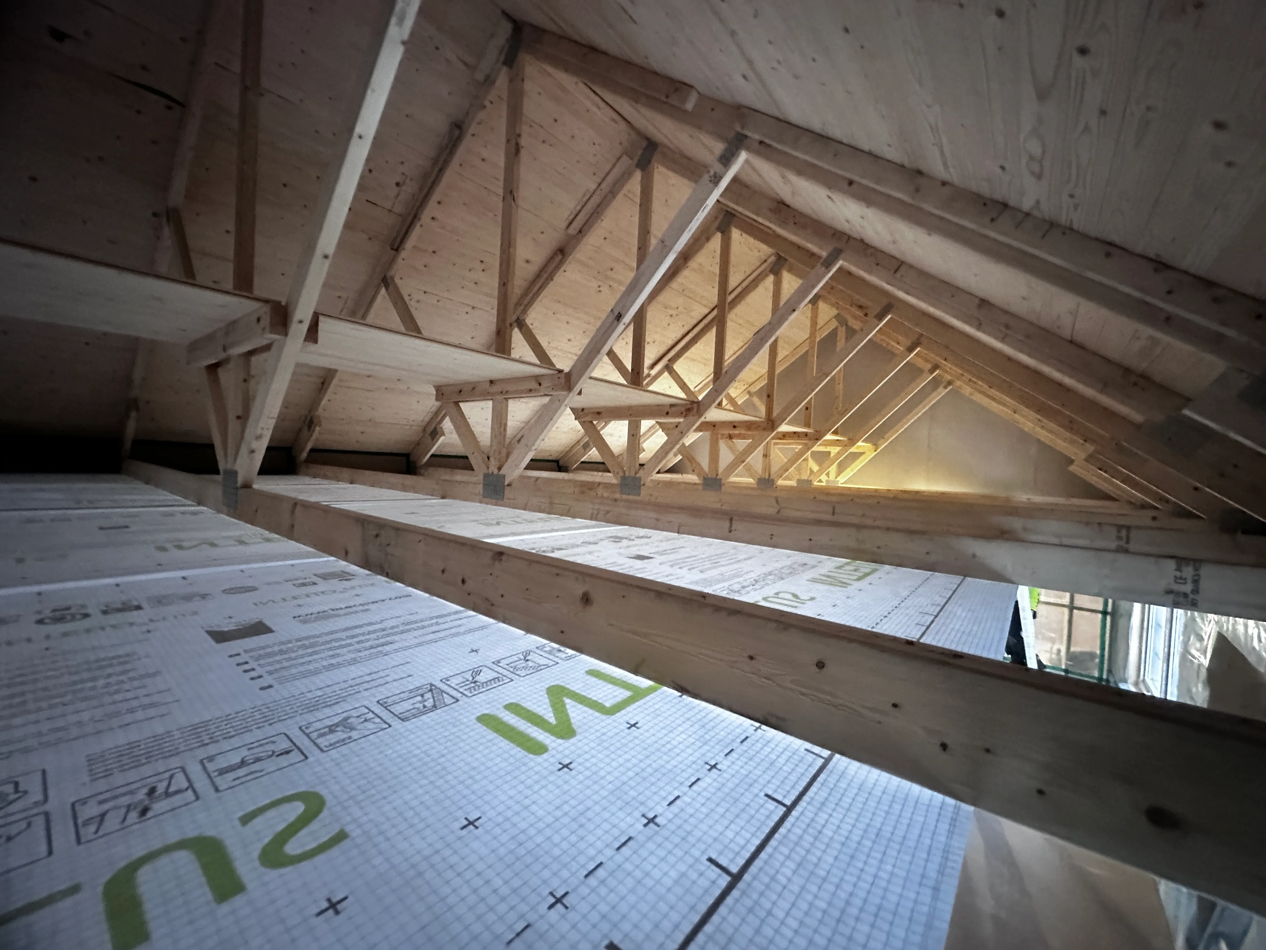 Taktkonstruktion med träbjälkar och isolering i en husrenovering