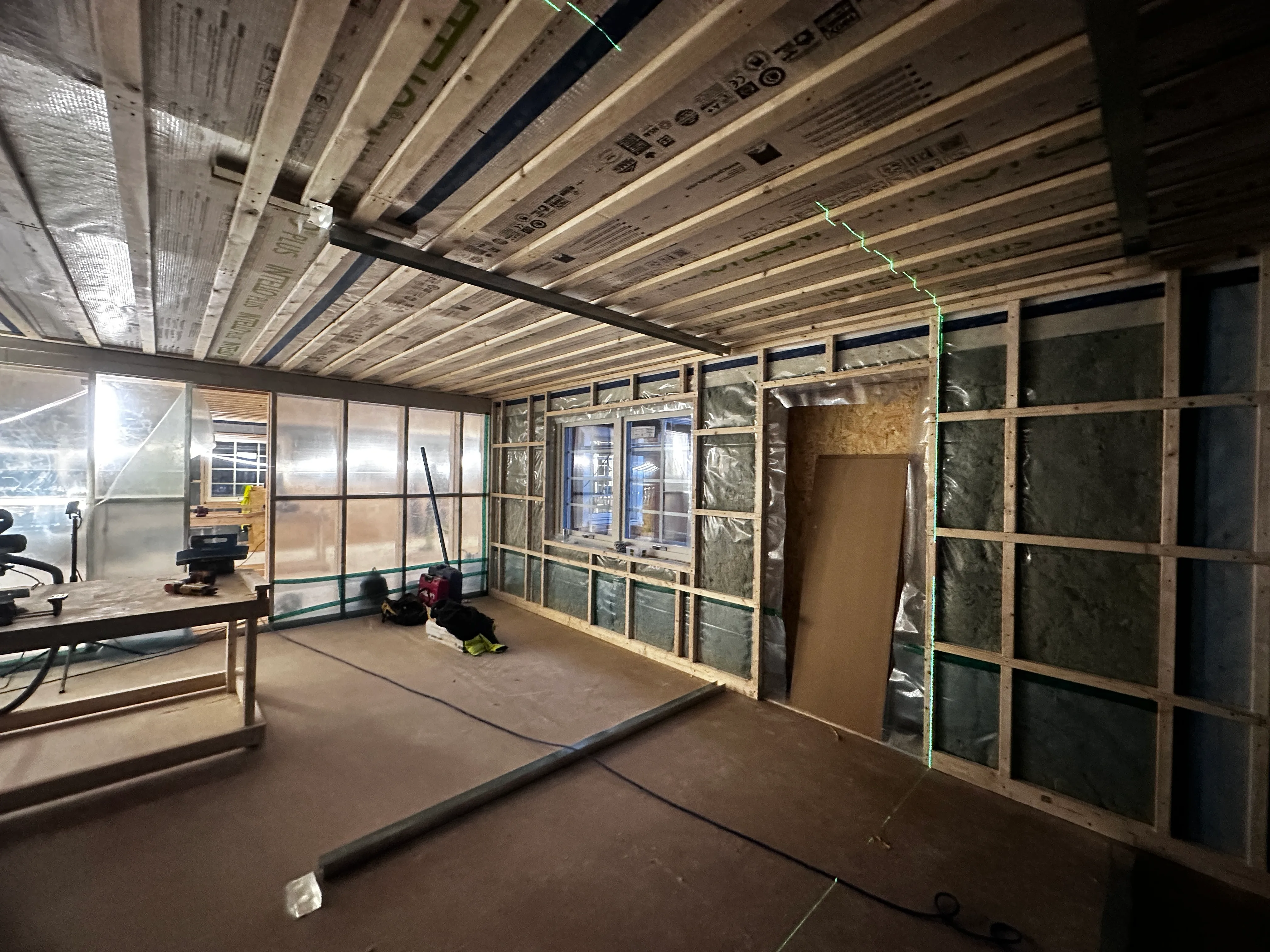 Inuti en byggplats med trästomme, isolering och fönster för renovering