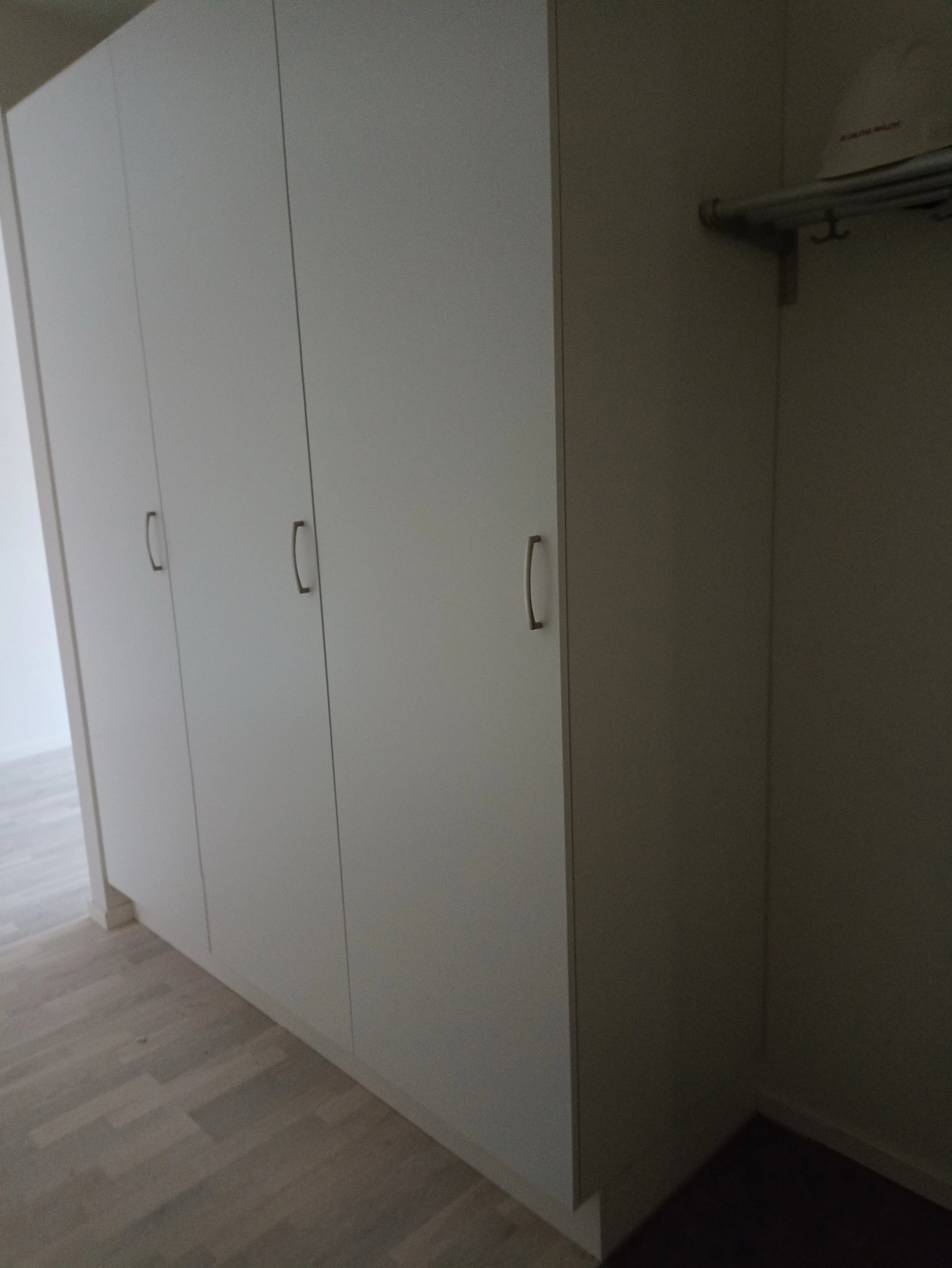 Vitt skåp med flera dörrar i ett rum för renovering