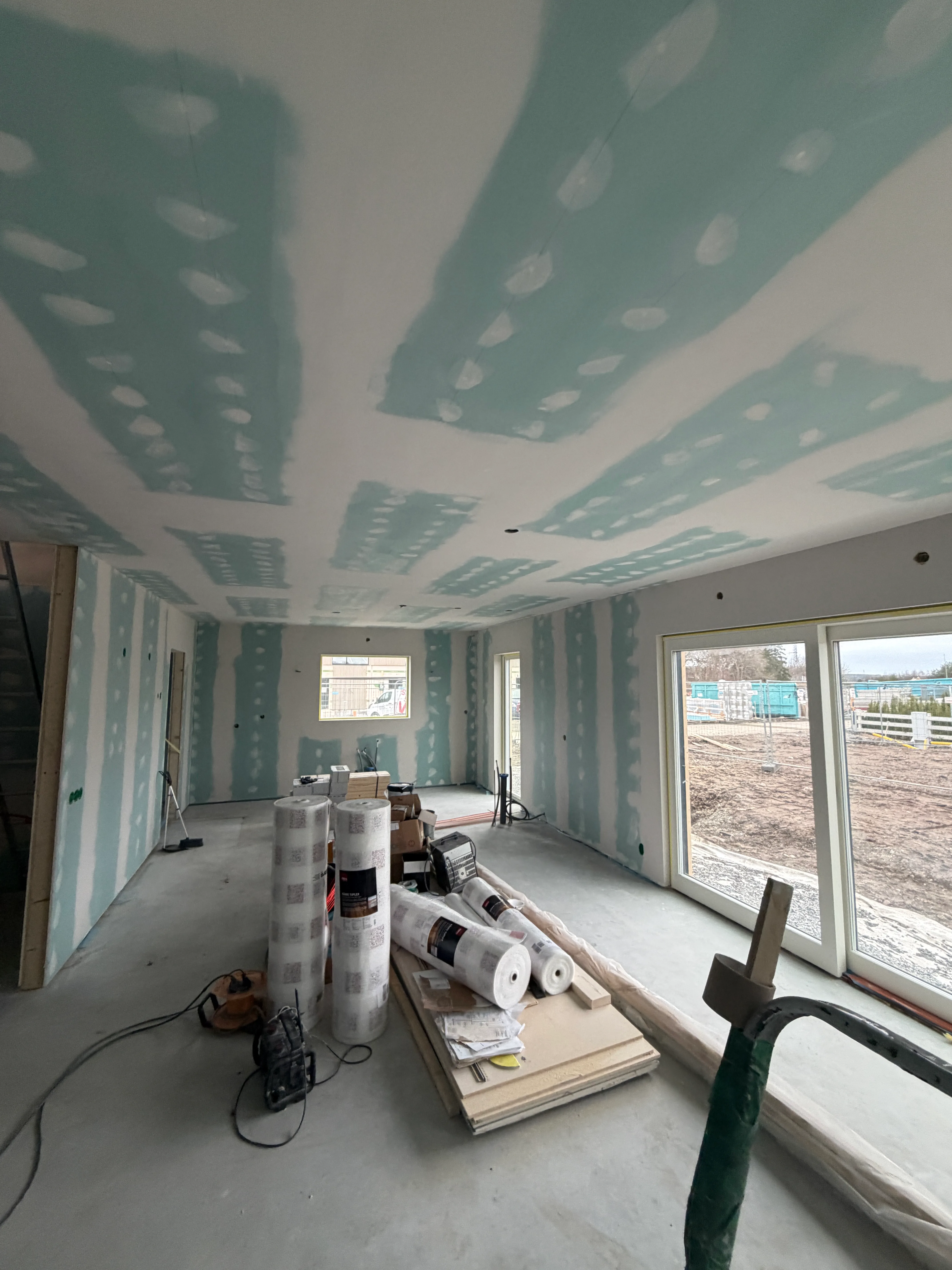 Inomhusmiljö med nyständiga väggar och förberedelse för målning i ett byggprojekt