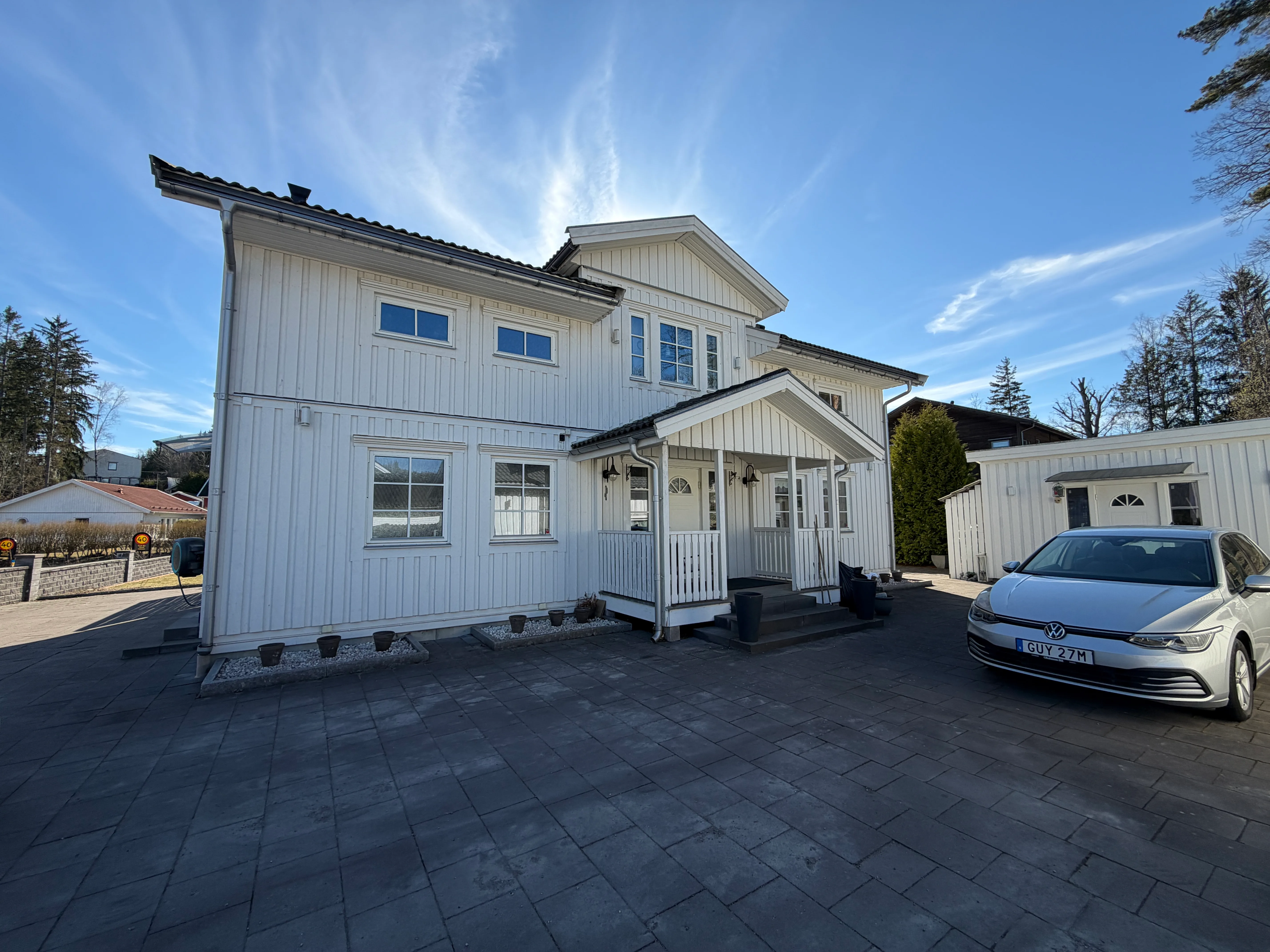 Renoverat hus med vit träfasad och nybyggd veranda i fokus