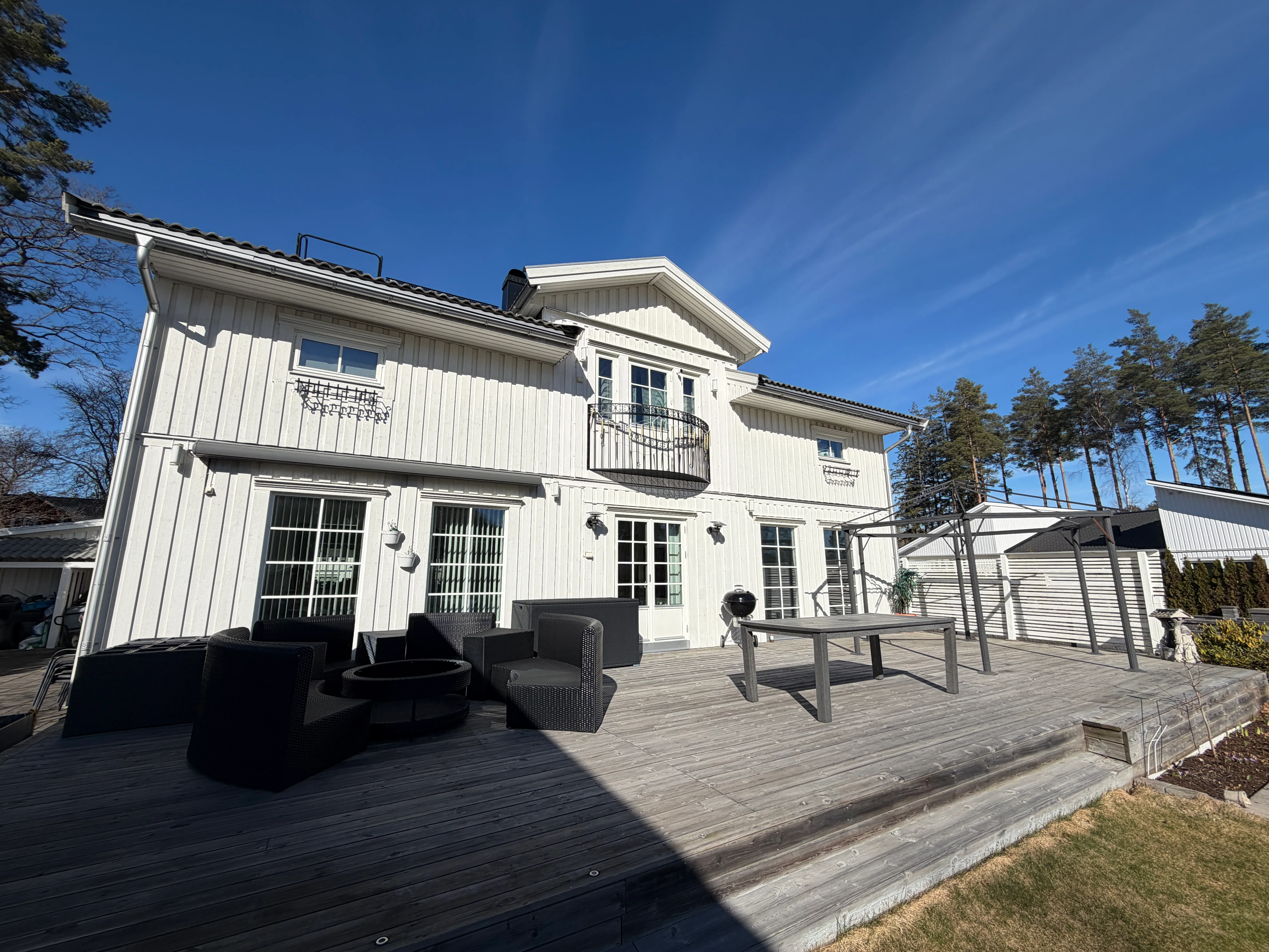 Modernt vitt bostadshus med träaltan