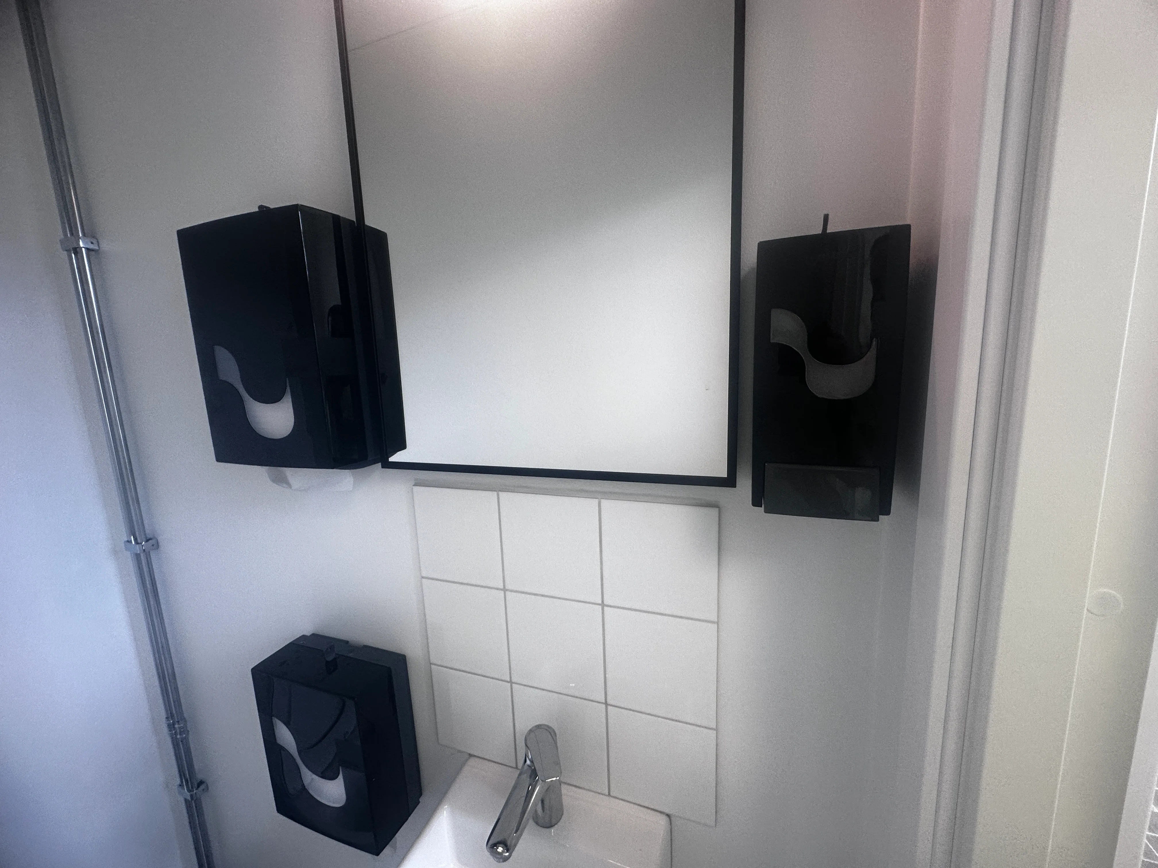 Spegel med svarta vägglampor i ett modernt badrum