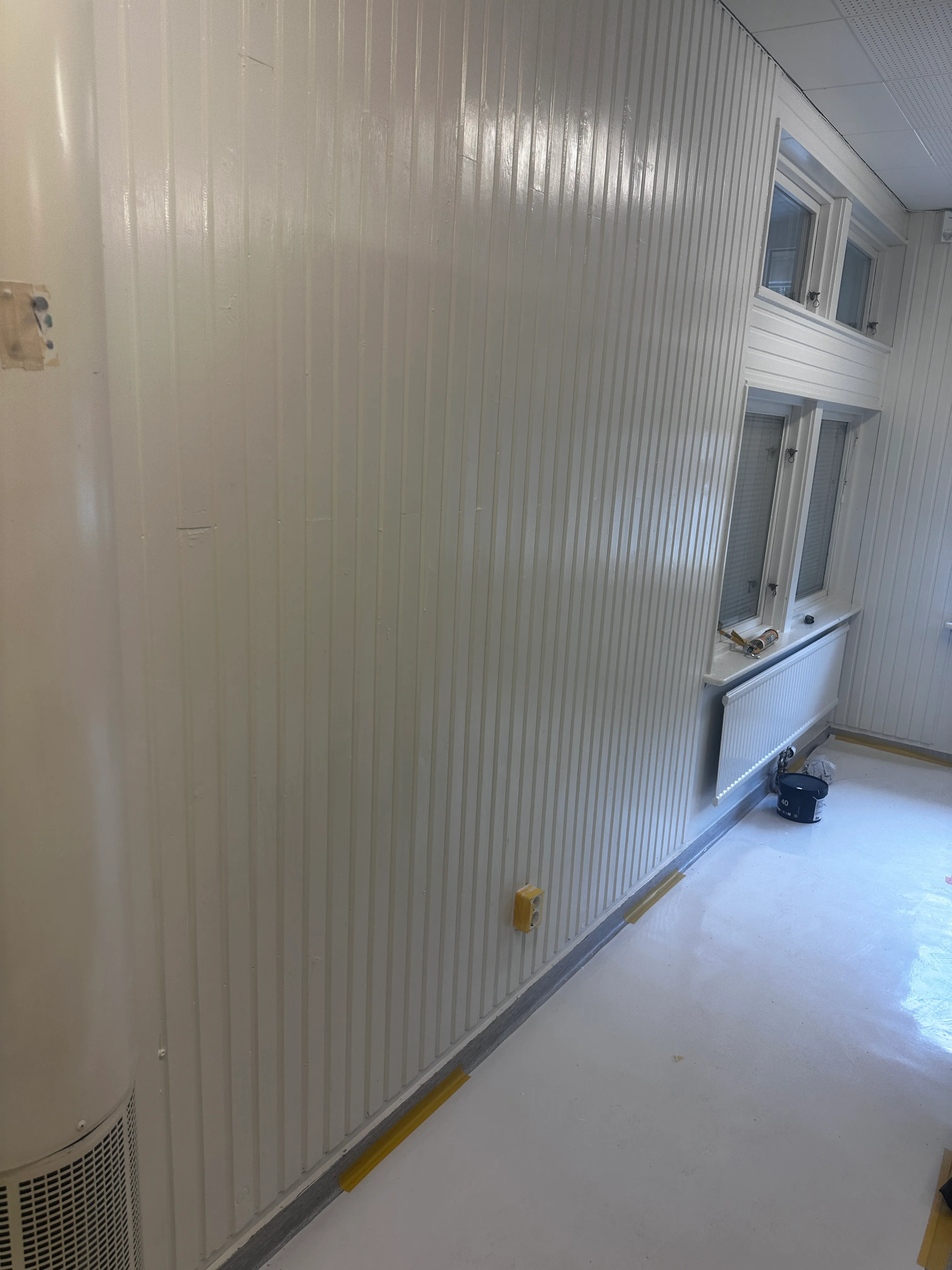 Renovering av inre väggar med vit panel och ny golvyta