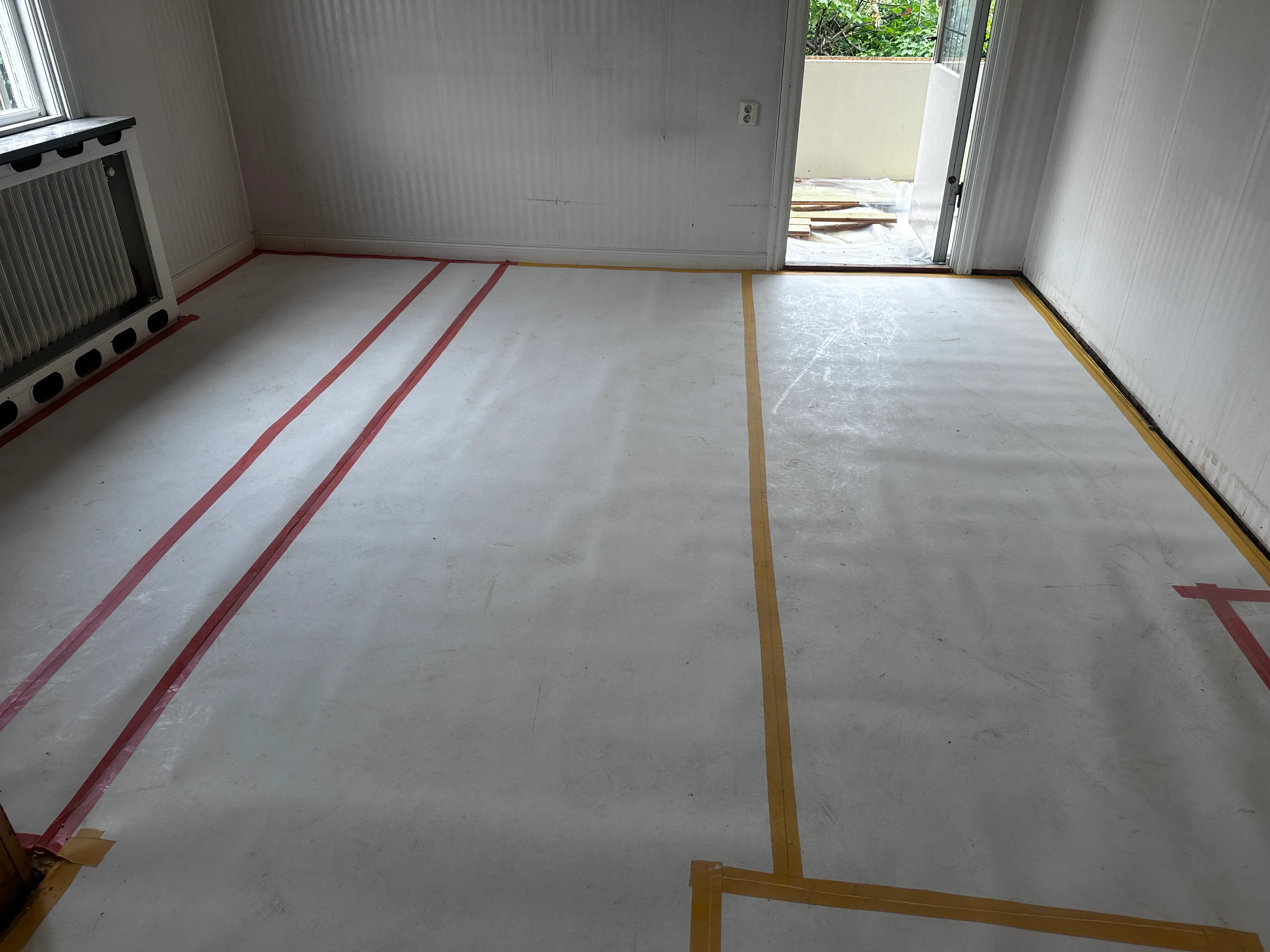 Golvyta med målad avgränsning för renovering, allt i en ljus miljö