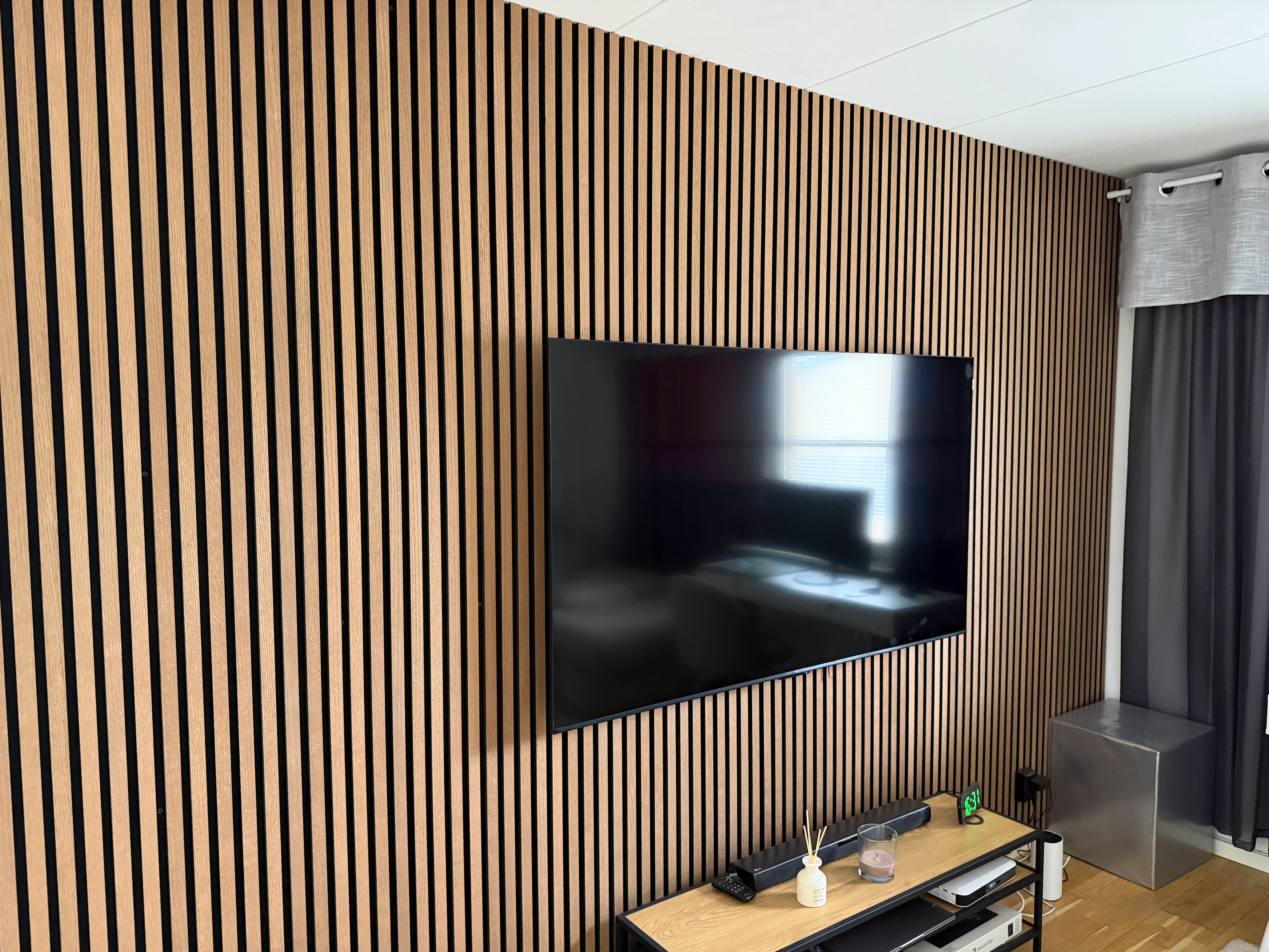 Vardagsrum med vertikal träväggpanel och TV