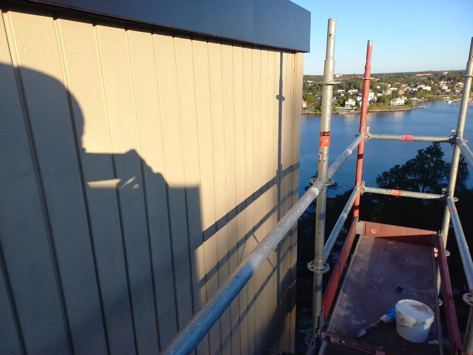 Byggnadsarbete med fasadinstallation vid vattnet