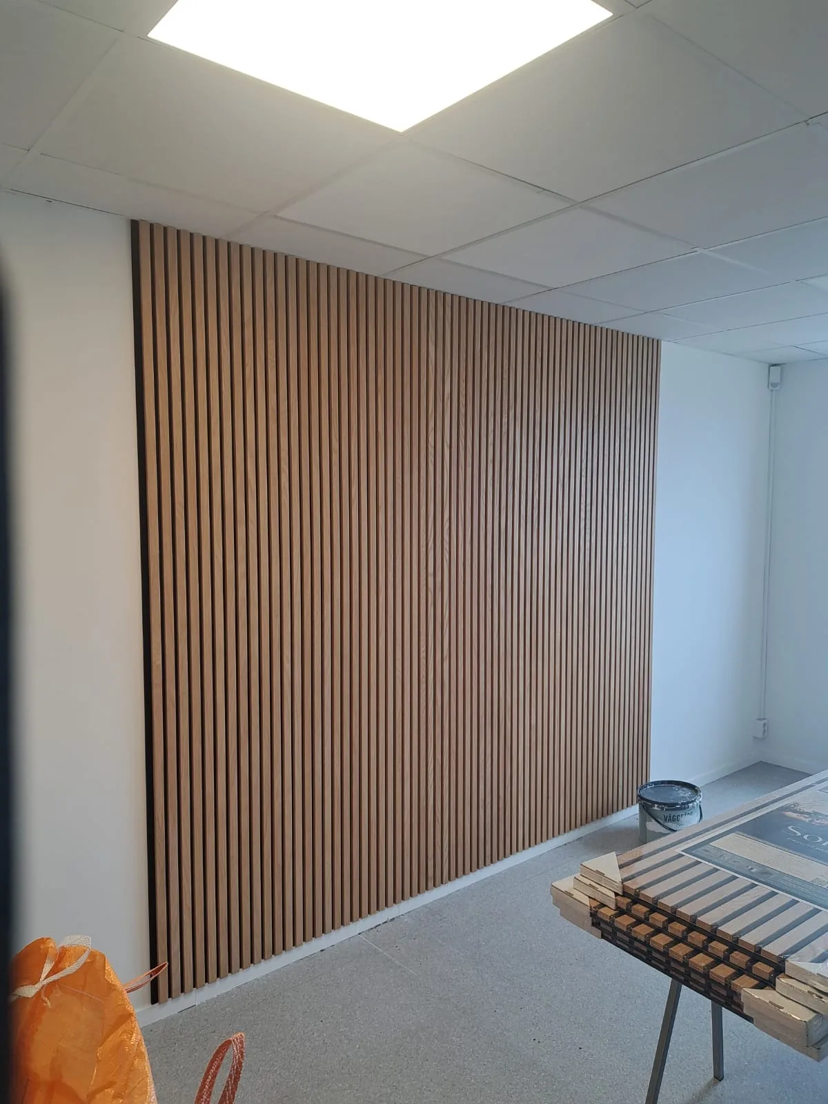 Vacker träpanel vägginstallation med vertikala plankor i ett ljust rum