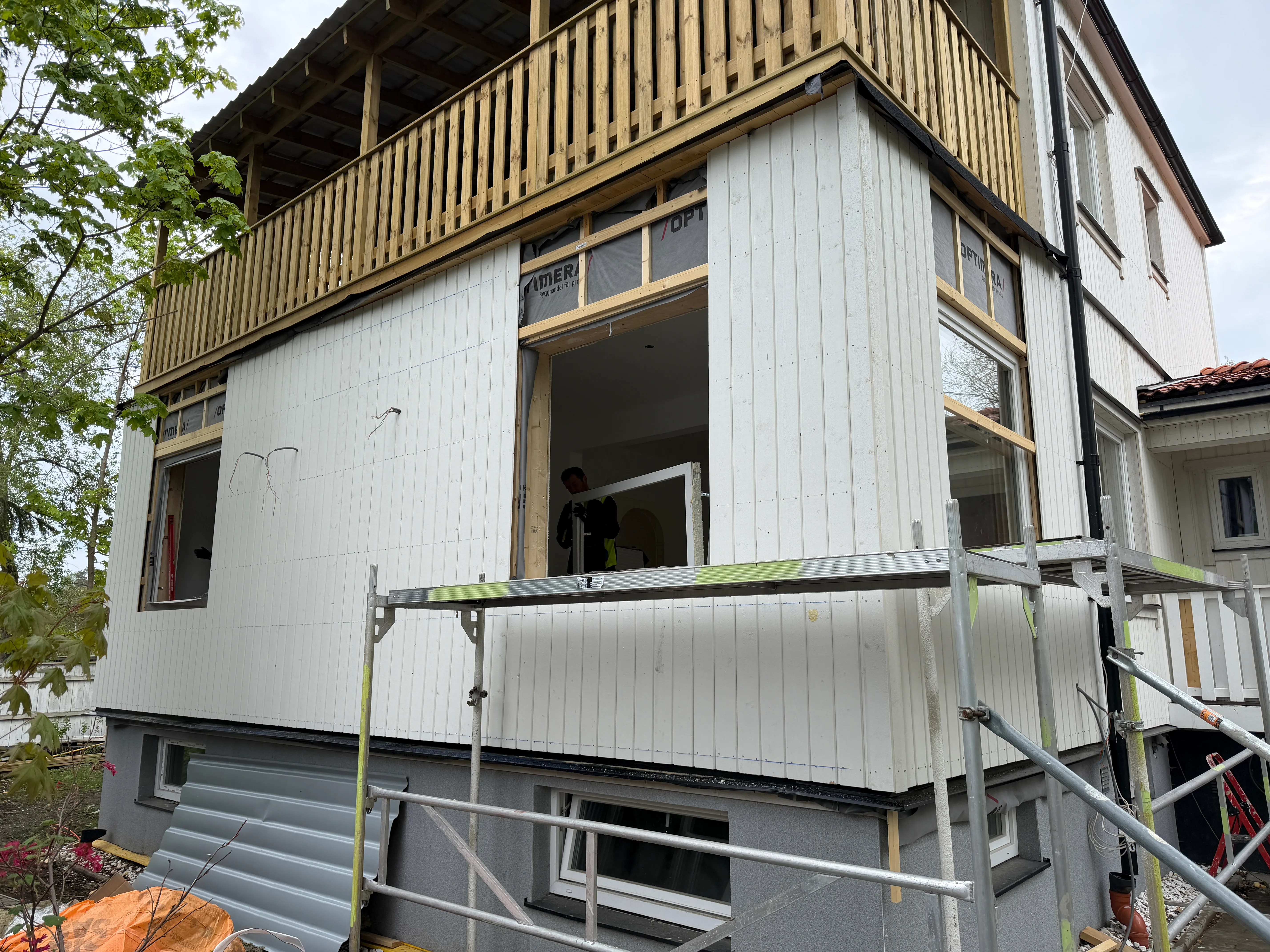 Pågående renovering av en fasad med en ny balkong på en byggnad