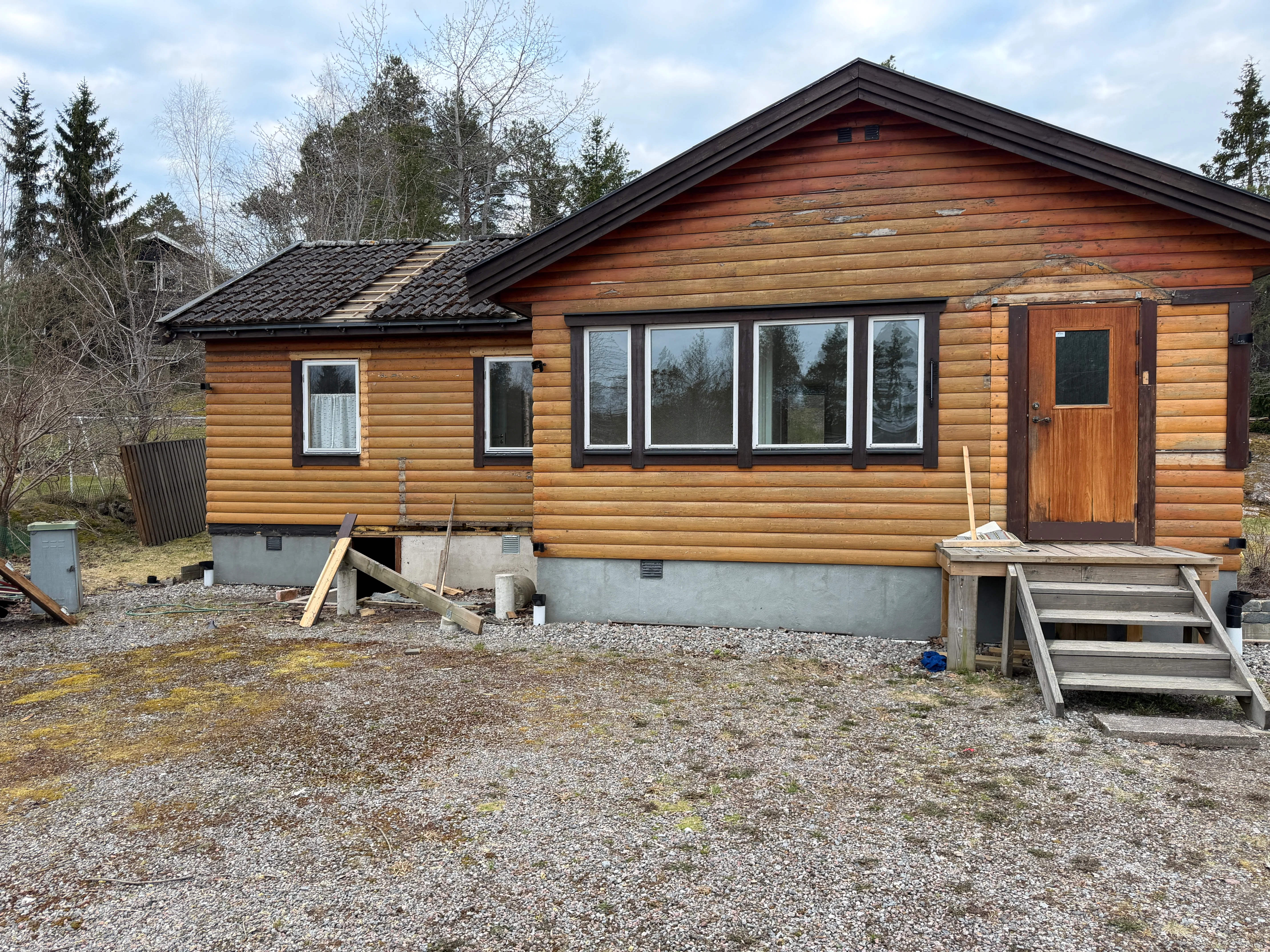 Husrenovering av en träbyggnad med fönster och dörr i fokus